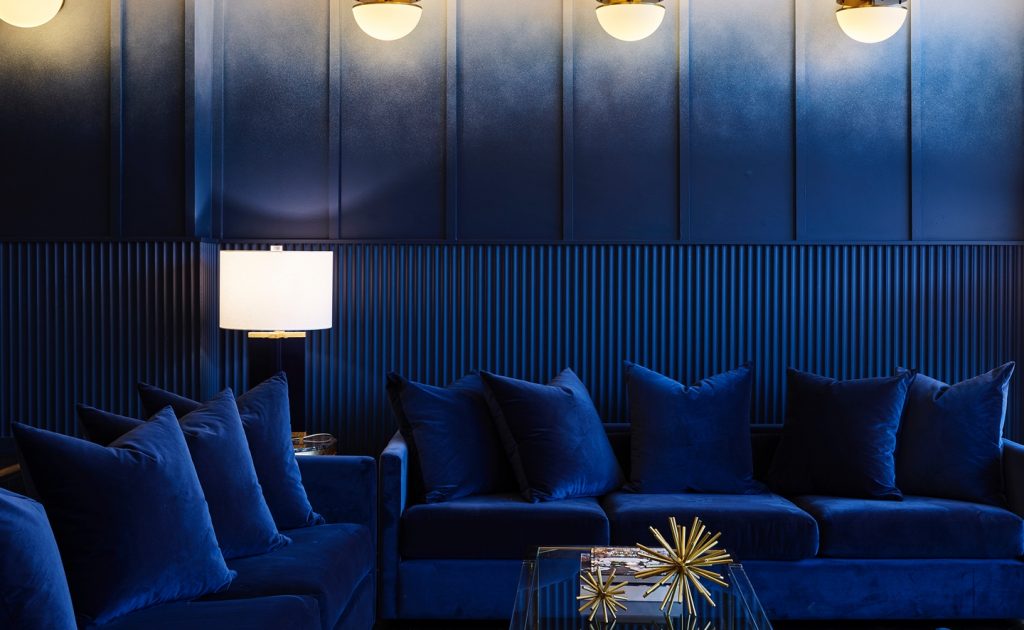 A wide shot of the le plonc blue ombre wall with blue couches and cushions. Designed by Greg Natale